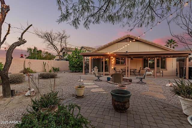 back house at dusk with a patio