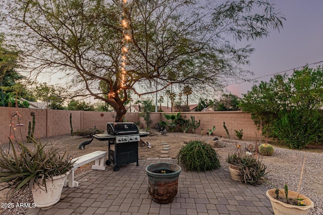 patio terrace at dusk featuring area for grilling