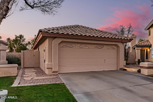 view of garage at dusk