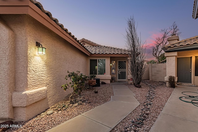 exterior entry at dusk featuring a patio area