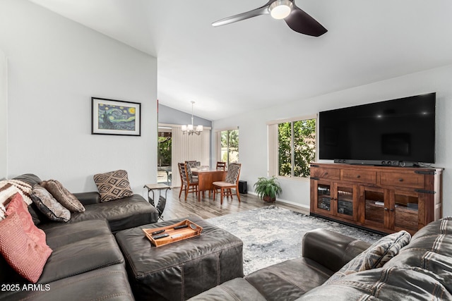 living room featuring hardwood / wood-style flooring, lofted ceiling, and ceiling fan with notable chandelier