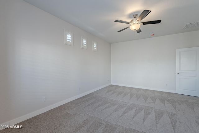 empty room featuring ceiling fan and light carpet