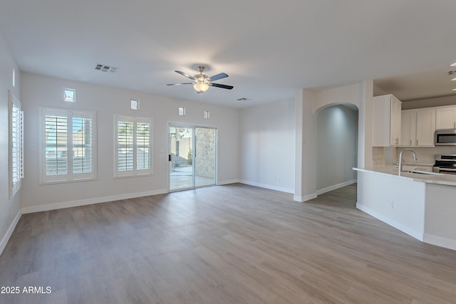 interior space featuring sink, ceiling fan, and light hardwood / wood-style flooring