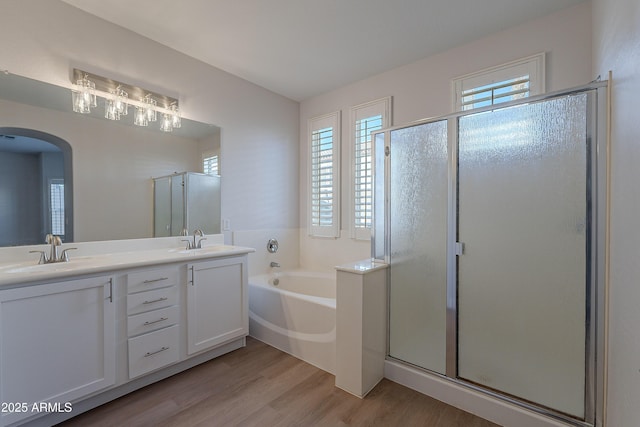 bathroom with hardwood / wood-style flooring, shower with separate bathtub, and vanity