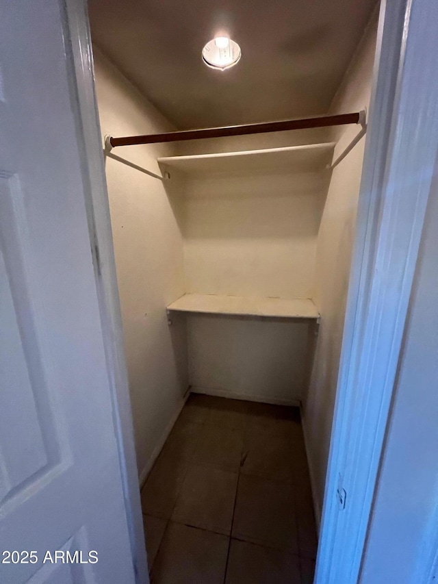 spacious closet with dark tile patterned flooring