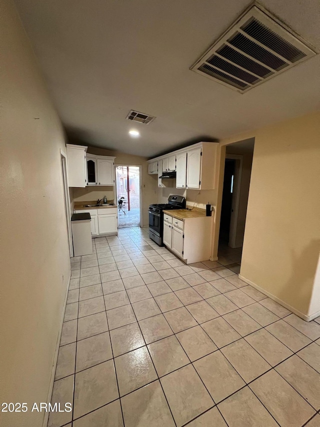 kitchen featuring sink, white cabinetry, range with gas stovetop, and light tile patterned flooring