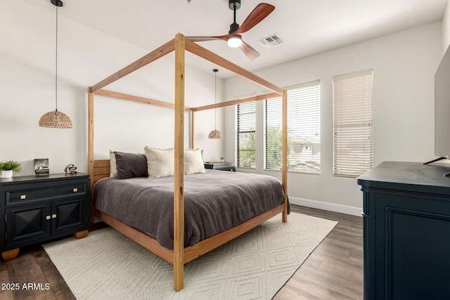 bedroom with baseboards, a ceiling fan, wood finished floors, and visible vents