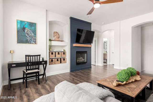 7445 E Eagle Crest Dr Unit 1145, Mesa, AZ 85207 - living area with a fireplace, arched walkways, a ceiling fan, baseboards, and wood finished floors