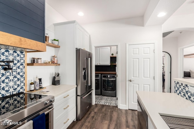 kitchen with light countertops, arched walkways, appliances with stainless steel finishes, and washer and dryer