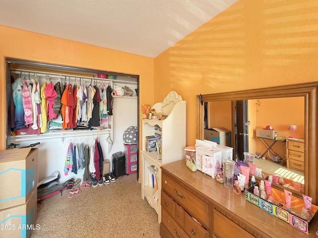 spacious closet featuring lofted ceiling and light colored carpet