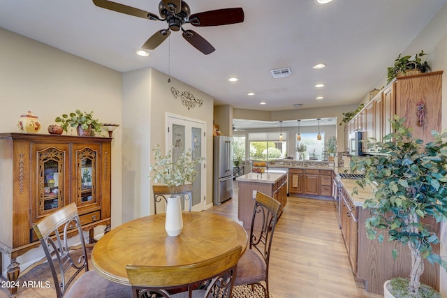 dining area featuring sink, light hardwood / wood-style flooring, and ceiling fan