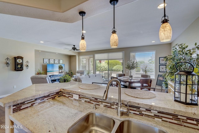 kitchen with sink, decorative light fixtures, and a wealth of natural light