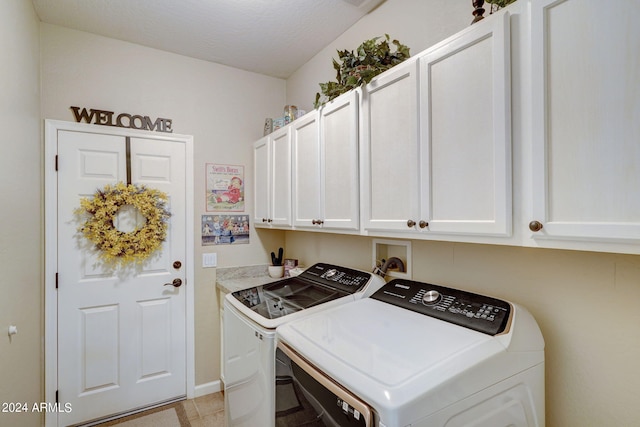 laundry area with separate washer and dryer and cabinets