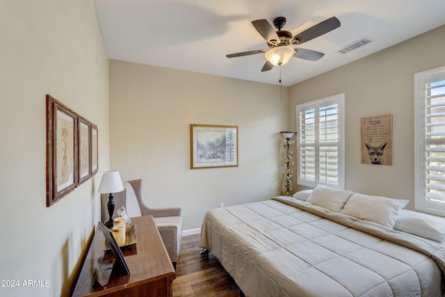 bedroom with multiple windows, dark wood-type flooring, and ceiling fan