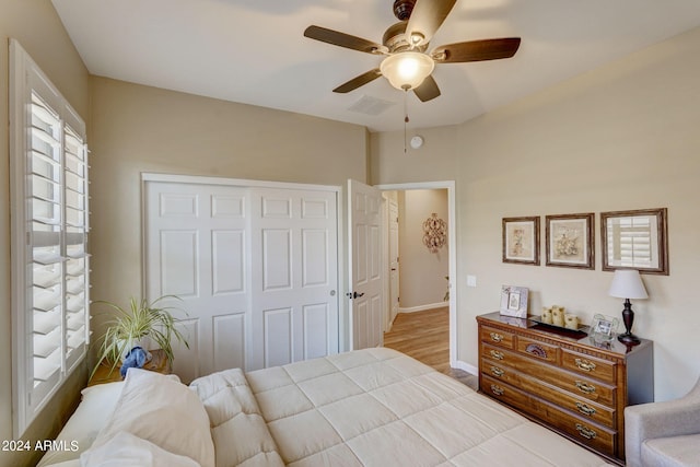 bedroom with light hardwood / wood-style flooring, a closet, and ceiling fan