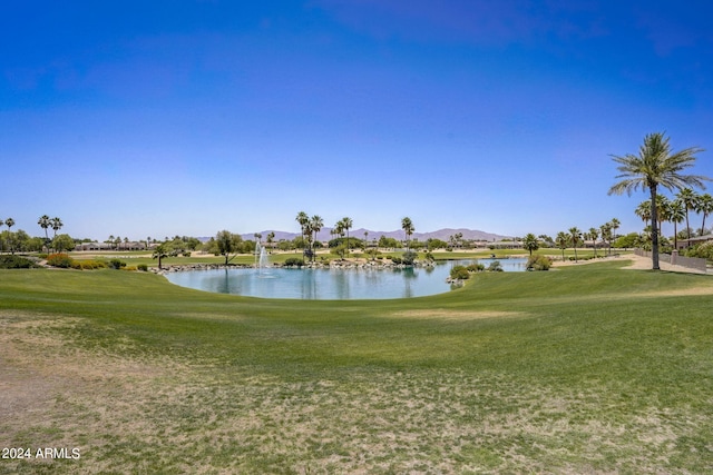 view of home's community with a water and mountain view and a lawn