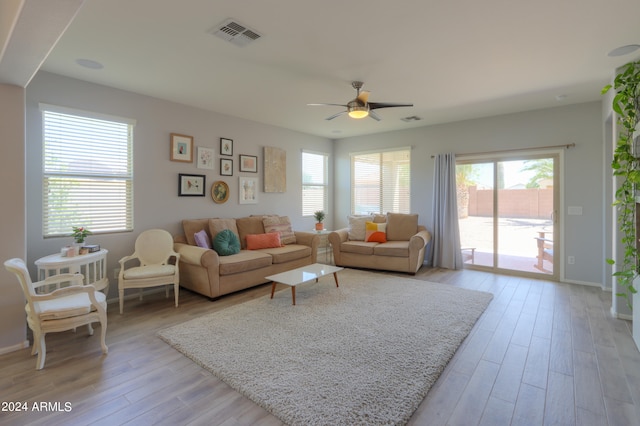 living room featuring light hardwood / wood-style flooring and ceiling fan