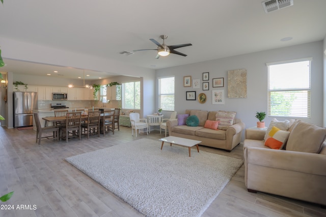 living room with ceiling fan and light wood-type flooring