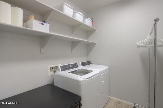 laundry room with light hardwood / wood-style flooring, washer hookup, and separate washer and dryer