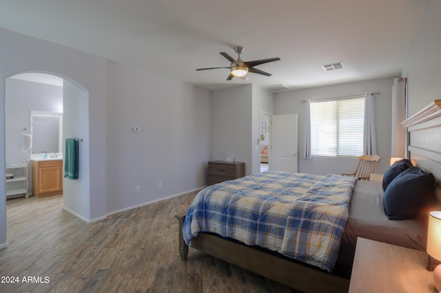 bedroom featuring ensuite bath, wood-type flooring, and ceiling fan