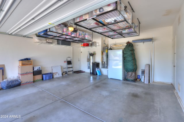 garage featuring white refrigerator and gas water heater