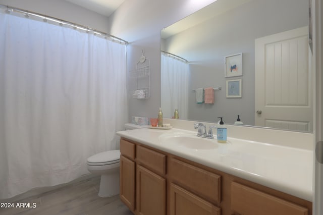 bathroom with hardwood / wood-style floors, vanity, and toilet