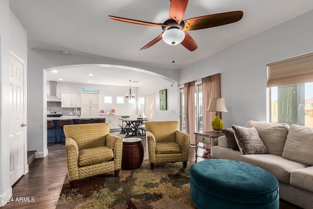 living room with ceiling fan with notable chandelier, dark hardwood / wood-style flooring, and sink