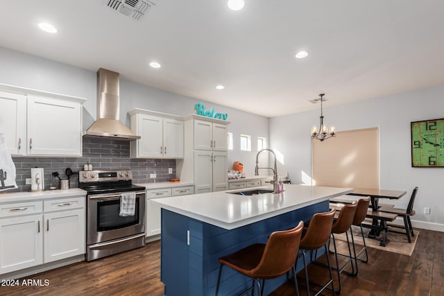 kitchen featuring a kitchen island with sink, dark wood-type flooring, white cabinets, electric range, and wall chimney exhaust hood