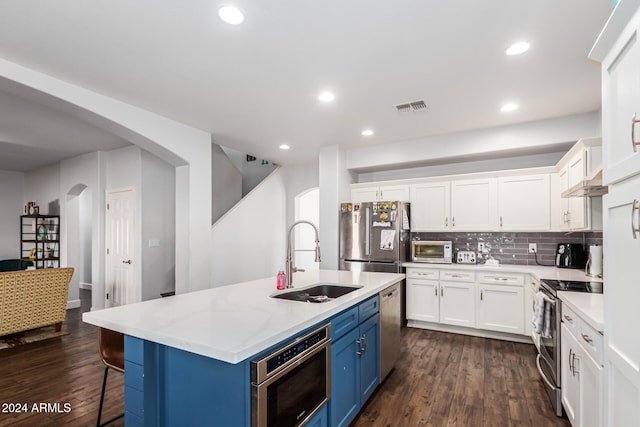 kitchen featuring a kitchen island with sink, sink, blue cabinetry, dark hardwood / wood-style flooring, and stainless steel appliances