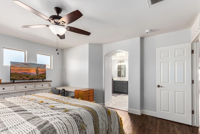 bedroom with ceiling fan, ensuite bathroom, and dark wood-type flooring