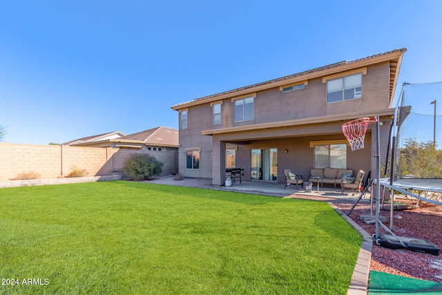 rear view of house featuring a lawn, outdoor lounge area, a patio, and a trampoline