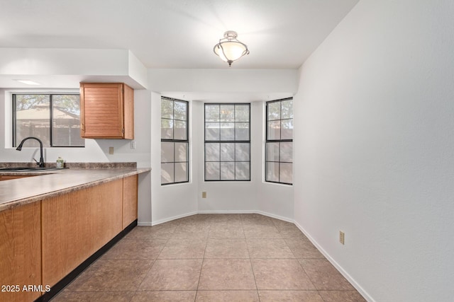 kitchen featuring plenty of natural light, sink, and light tile patterned floors