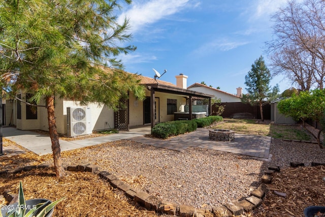 rear view of house featuring a patio, a storage unit, and a fire pit