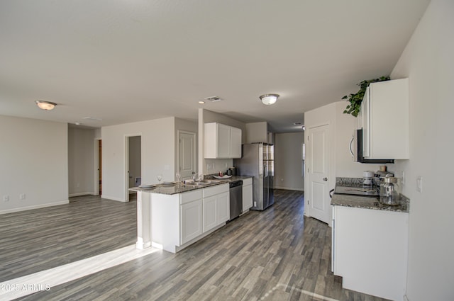 kitchen featuring white cabinetry, sink, appliances with stainless steel finishes, and dark stone counters