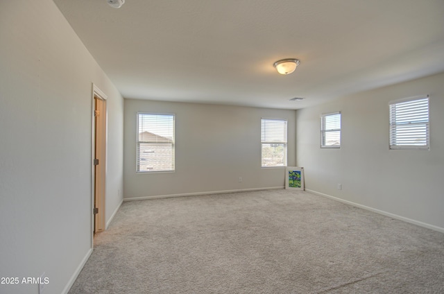 empty room featuring a healthy amount of sunlight and light colored carpet