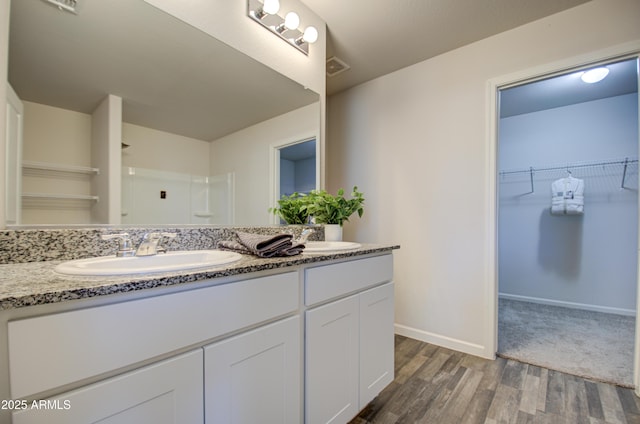 bathroom featuring hardwood / wood-style flooring, vanity, and a shower