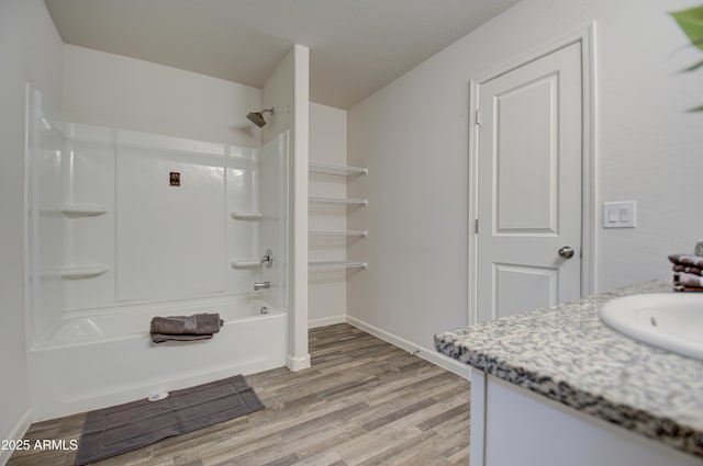 bathroom with bathing tub / shower combination, vanity, and hardwood / wood-style flooring