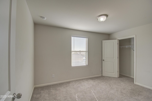 unfurnished bedroom with a closet and light colored carpet