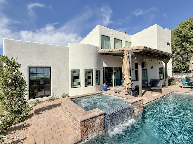 rear view of property with a patio, an in ground hot tub, an outdoor pool, stucco siding, and a tiled roof