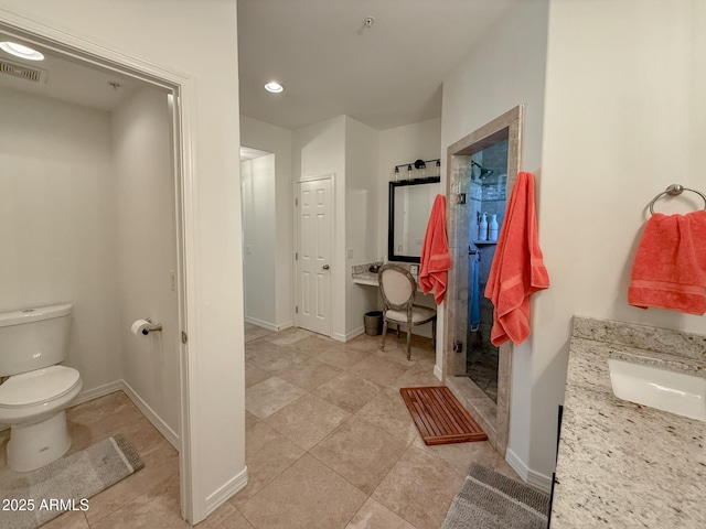 bathroom featuring vanity, visible vents, baseboards, a stall shower, and toilet