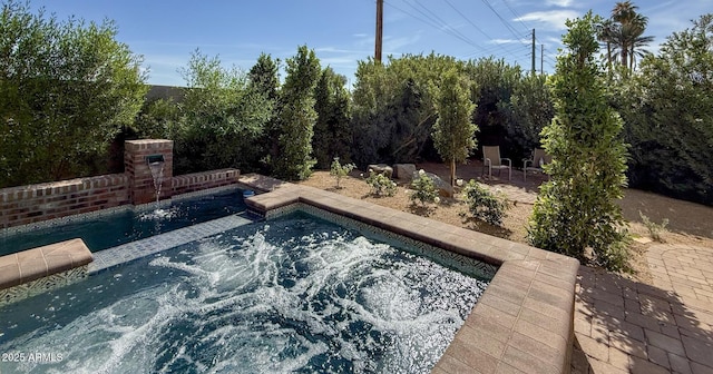 view of swimming pool featuring a patio and a hot tub