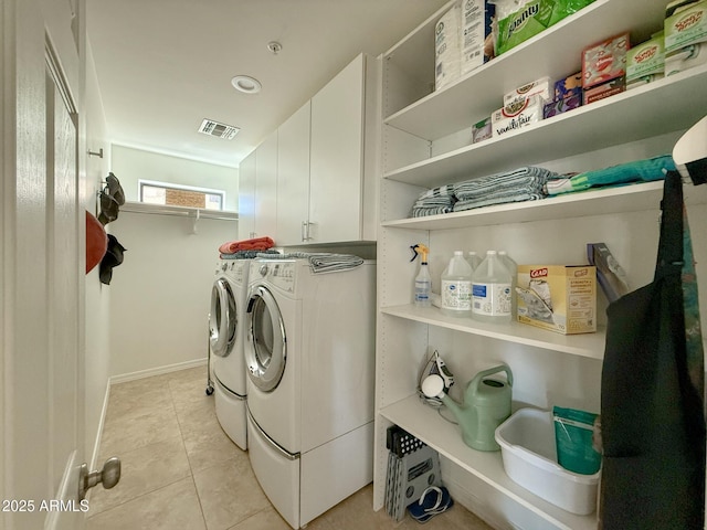 laundry room with light tile patterned floors, baseboards, visible vents, cabinet space, and washer and clothes dryer