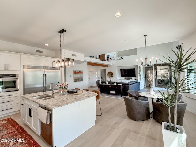 kitchen with a sink, visible vents, light wood-type flooring, and appliances with stainless steel finishes