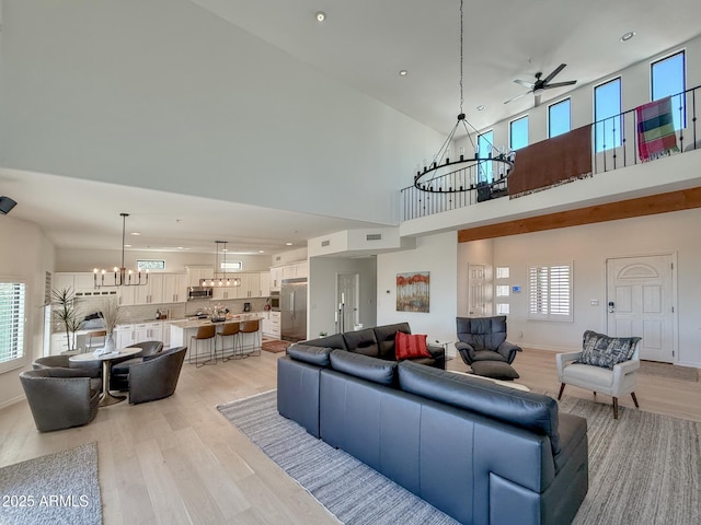 living room featuring visible vents, light wood finished floors, baseboards, recessed lighting, and ceiling fan with notable chandelier