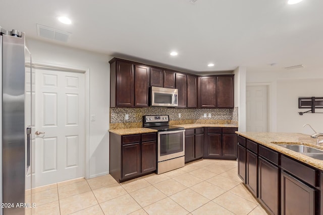kitchen featuring stainless steel appliances, a sink, light tile patterned flooring, backsplash, and recessed lighting