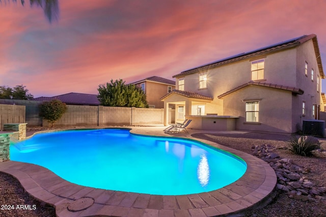 view of swimming pool with a patio, a fenced backyard, cooling unit, and an outdoor kitchen