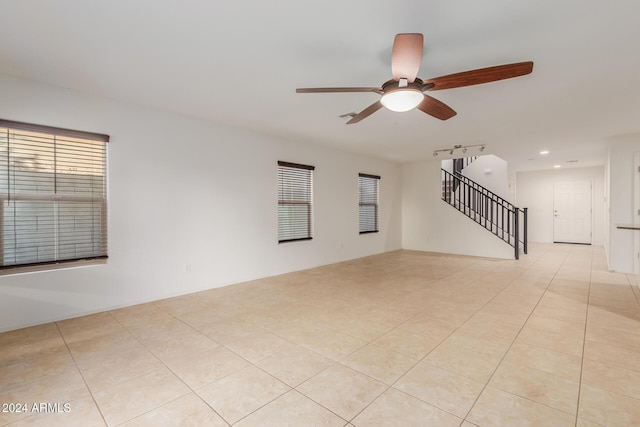 empty room featuring a ceiling fan, stairway, light tile patterned flooring, plenty of natural light, and recessed lighting