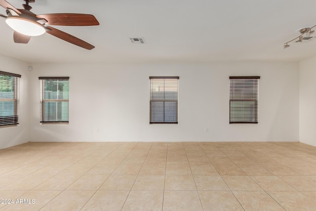 empty room with plenty of natural light and a ceiling fan