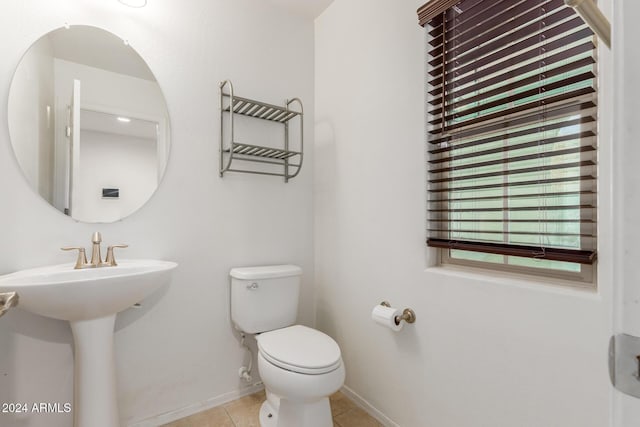 bathroom featuring toilet, tile patterned flooring, baseboards, and a sink