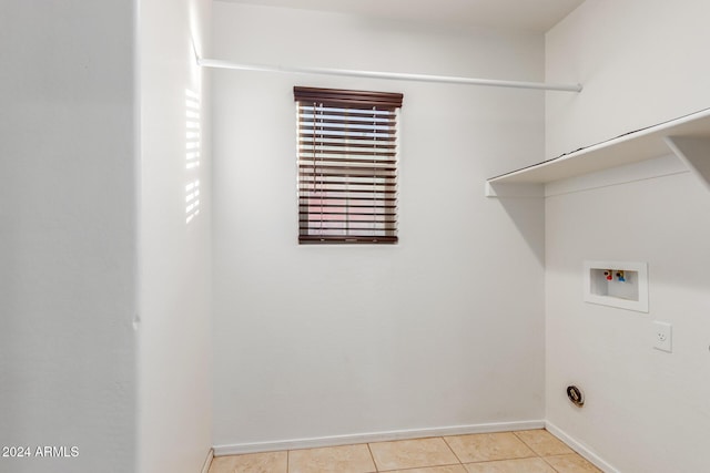 clothes washing area featuring hookup for a washing machine, baseboards, and light tile patterned floors